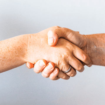 Image of a womanâ€™s and a manâ€™s hand shaking one another.